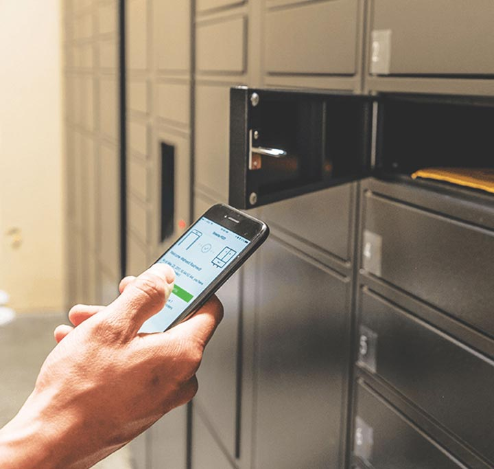 man holding phone up to smart locker